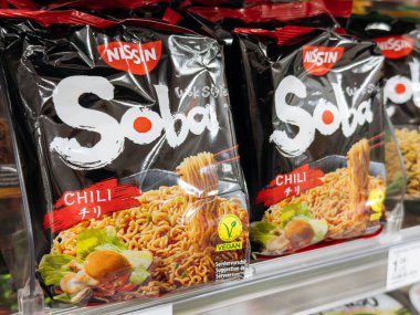 Villach, Austria - September 28, 2025: Nissin Soba Chili instant noodles packaging is prominently displayed on a supermarket shelf, highlighting its vibrant design