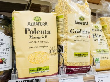 Villach, Austria - September 28, 2025: Alnatura Polenta and Goldhirse packages are prominently displayed on a supermarket shelf filled with organic grain products