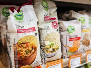Villach, Austria - September 28, 2025: Organic food products on supermarket shelf include bulgur, quinoa, and lentils, emphasizing healthy eating choices