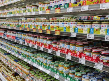 Villach, Austria - September 28, 2025: Shelves display an array of HiPP baby food jars, offering diverse flavors and options for parents shopping in a grocery store