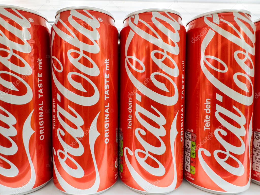 Villach, Austria - September 28, 2025: Coca-Cola cans arranged neatly in a fridge, highlighting the bright red color and recognizable branding for promotional use