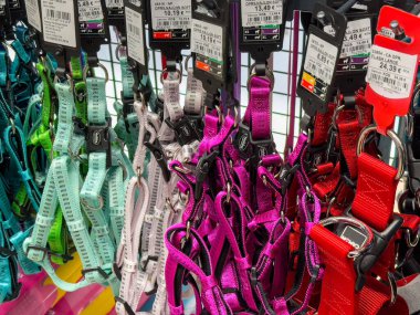 Ljubljana, Slovenia - October 02, 2025: Vibrant pet harnesses in multiple colors are neatly arranged on a retail display, ideal for pet owners looking for stylish choices