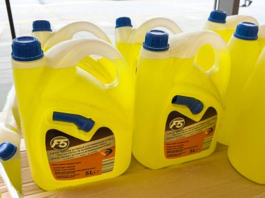 Ljubljana, Slovenia - October 02, 2025: Bright yellow cleaning product bottles are neatly arranged on display in a retail environment, emphasizing brand visibility and product appeal