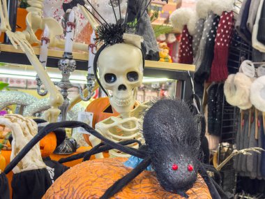 Ljubljana, Slovenia - October 02, 2025: Halloween decor showcases a skeleton and a spider on a pumpkin, enhancing the spooky vibe of the season