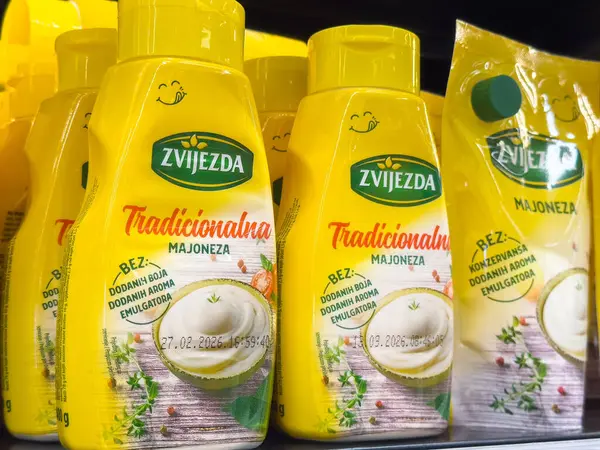 Ljubljana, Slovenia - October 02, 2025: Zvijezda traditional mayonnaise bottles are neatly arranged on a supermarket shelf, highlighting their bright yellow color and appealing design