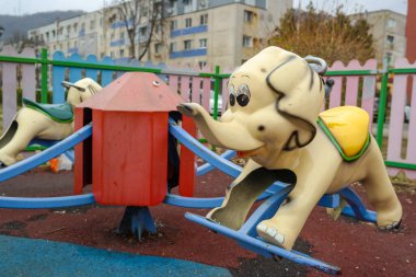 1990 'ların fili parktaki çocuk atlıkarınca parkında geziyor. Romanya, Avrupa. Yüksek kalite fotoğraf