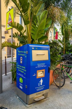 Nice, France, 04.04.2025: Yellow and blue solar-powered waste and cigarette butt collection containers on the English Embankment. High quality photo