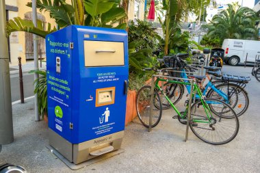 Nice, France, 04.04.2025: Yellow and blue solar-powered waste and cigarette butt collection containers on the English Embankment. High quality photo