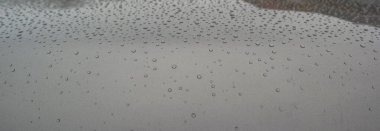 Yağmurlu bir günde bir arabanın gri kaputunda yağmur damlaları. Geçmişi. Yüksek kalite fotoğraf