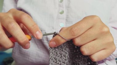 Pamuk ipliğiyle örgü ören bir kız. Turuncu örgü, basit örgü deseni. Tığ işi. Yüksek kalite 4k görüntü