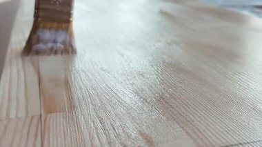 Ahşap tahtaların vernikli tedavisi. Tahtaya bir fırçayla cila sürüyorum. İnşaat, ahşap işleme, gebelik ve dış etkilerden korunma. Yüksek kalite 4k görüntü