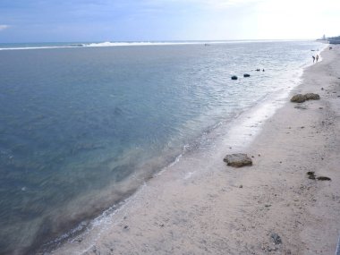 View of the shoreline from above, white waves, beach sand, clear water and rocks. Panoramic view. Beautiful beaches