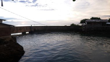 Afternoon sea view and sea-wall, beach, and coral, sunset background on Santolo beach Indonesia