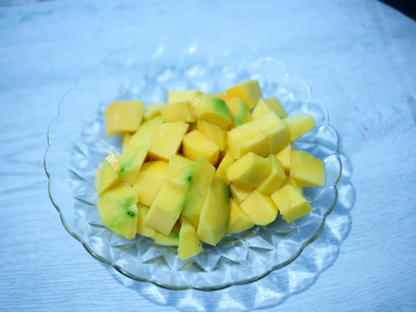 Mangos sliced cut to cubes on a glass plate , top view