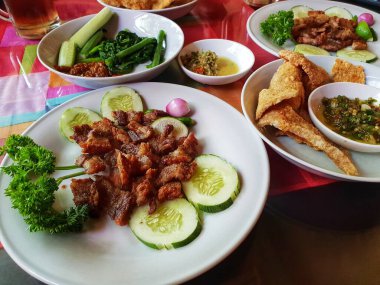 Izgara domuz eti ve kızarmış domuz eti ve yanında da acı biber.