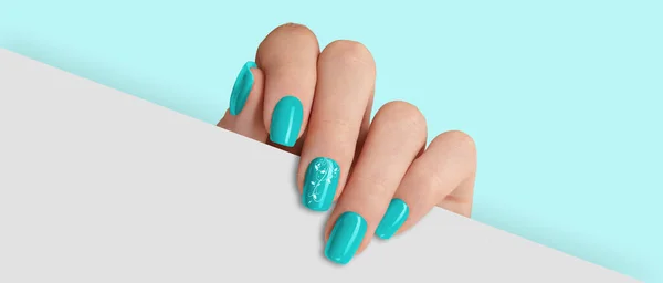 stock image Woman's hand holding white paper. Fashionable light blue nail design