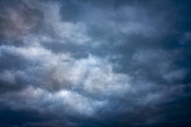 Çarpıcı bulutlarla dolu görkemli gökyüzü nefes kesici ve karamsar bir atmosfer yaratıyor. Işık ve gölgenin karışımı derinlik ve yoğunluk ekler, arka planlar, hava konseptleri ve doğa temalı tasarımlar için mükemmeldir..