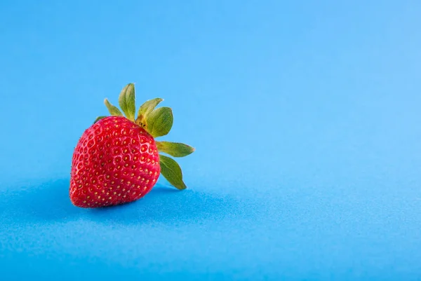 ripe red strawberries on a blue background