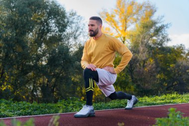 Yakışıklı sporcu parktaki açık havada idman yapıyor.