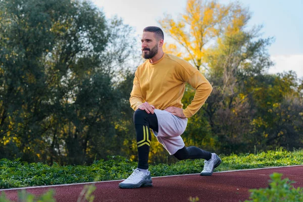 Yakışıklı sporcu parktaki açık havada idman yapıyor.