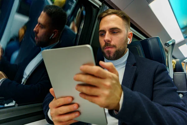 Attractive businessman with tablet researching ideas for a project or a new business