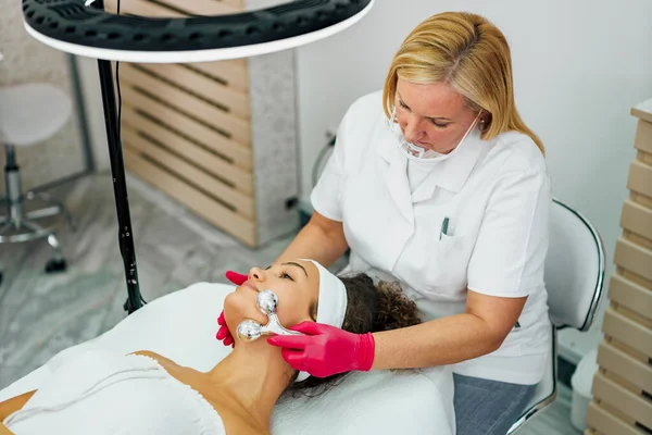 Masözün elleri masaj masasında güzellik salonunda uzanan güzel bir kadına masaj yapıyor.