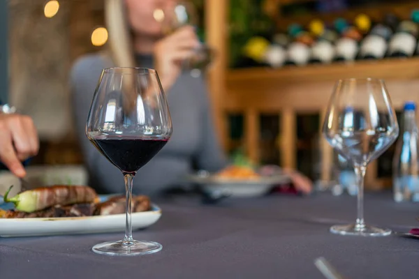 Lokantadaki masada bir bardak kırmızı şarap.