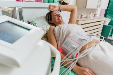 Kaplıca ve sağlık tedavisi gören genç bir kadının fotoğrafı, mutlu görünüyor.