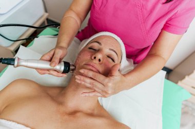 Kozmetik Güzellik Kliniği 'nde kadın yüz hidro soyma tedavisi görüyor..