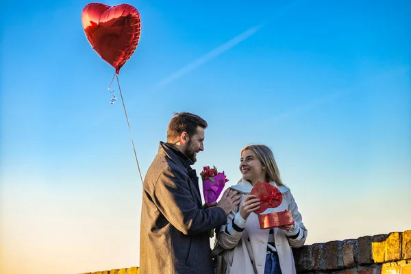 Üç kişilik mutlu bir aile yürüyor ve güzel bir kış gününün tadını çıkarıyor..