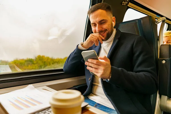 Businessman commuting by train, talking a phone discusses new project ideas