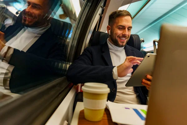 Proje yöneticisi, kahvesini içerken trenle gidip gelirken video üzerinden bir projenin sonuçlarını ve verilerini inceliyor.