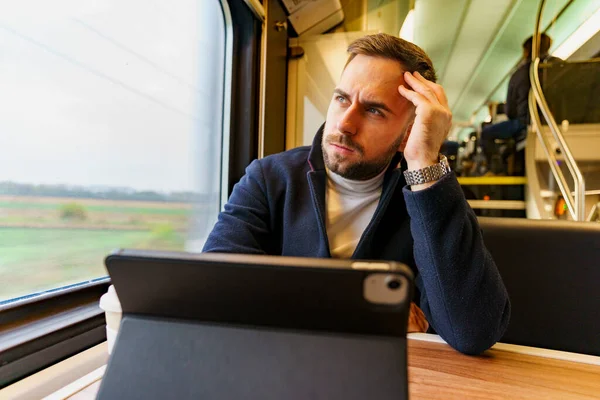 Commuter on his way to work using technology to catch up on his work load, he\'s stressed
