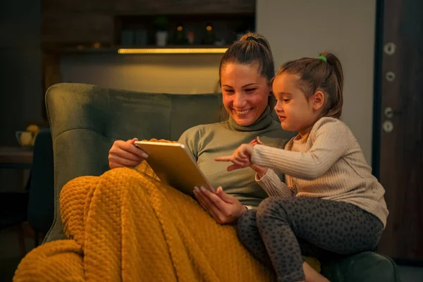 Anne ve kızı videolar izleyip gülüyorlar. Kış tatilinde birlikte çok güzel vakit geçiriyorlar.