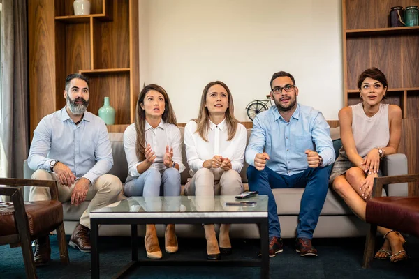 Üç kadın ve iki erkek çalışandan oluşan bir ekip işten sonra en sevdikleri spor takımı için tezahürat yapıyor.