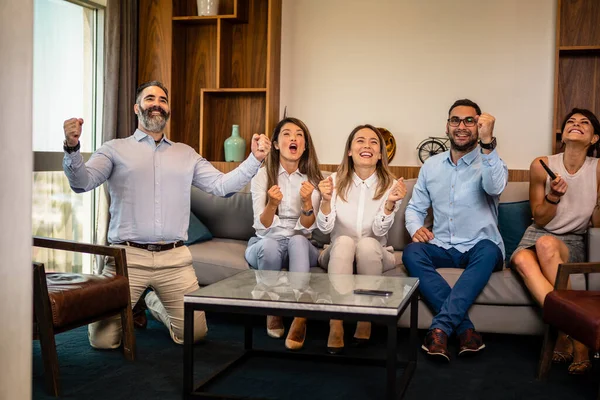 Üç kadın ve iki erkek çalışandan oluşan bir ekip işten sonra en sevdikleri spor takımı için tezahürat yapıyor.