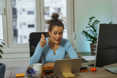 a young woman has an open discussion with her business partner via video call about their upcoming project