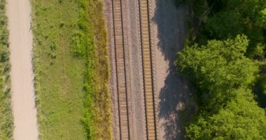 İkili demiryolu dokusunun üst hava görüntüsü. Kamera ileri gidiyor. Sol tarafta çakıllı bir yol görülebilir..
