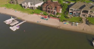 Göl kenarındaki evleri gösteren bir hava manzarası. Gökyüzü ve ufuk sona doğru görülebilir..