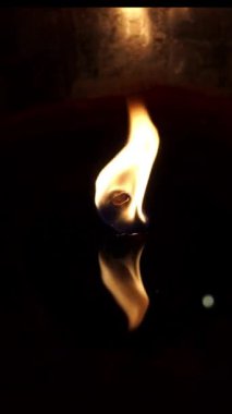 Parlak bir yüzeyde yanan ateşin videosunu kapat