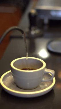 Bir bardağa sıcak su döken kişi