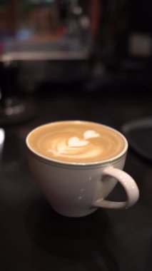 Masada köpüklü bir fincan kahve.