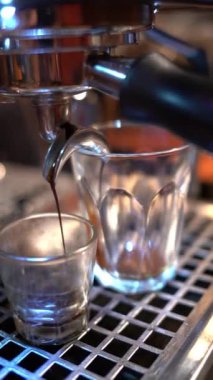 Kahve makinesi sıcak espresso dolduruyor.