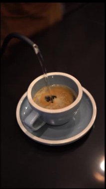 Bir bardağa sıcak su döken kişi