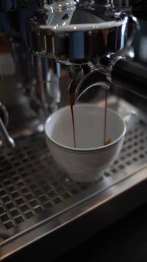 Buzlu Americano kahvesi yapmak için kahve makinesinde buzlu bir bardak suya espresso dökmek.