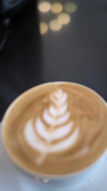 Masada köpüklü bir fincan sıcak latte.