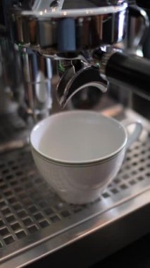 Kahve makinesi taze demlenmiş espresso dolduruyor.