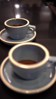 Kahve yapmak için bardağa sıcak su döken biri.