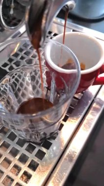 Kahve makinesi taze demlenmiş espresso dolduruyor.
