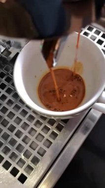 Kahve makinesi taze demlenmiş espresso dolduruyor.